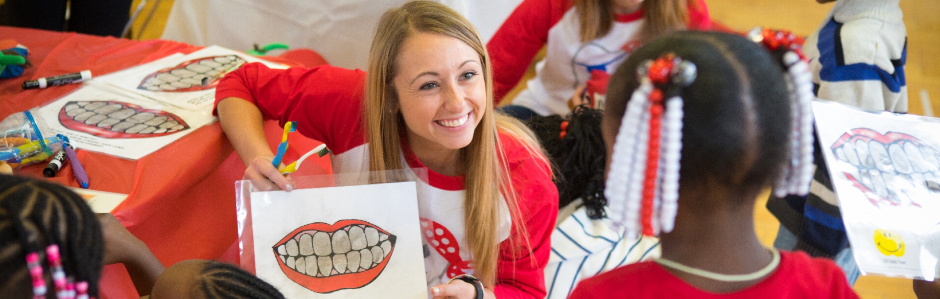 A student volunteer holding up a diagram of teeth. 