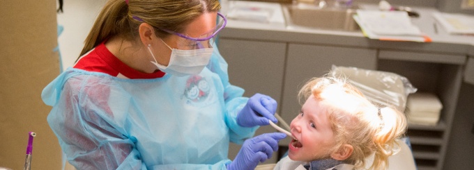 A dental student works on a young patient. 