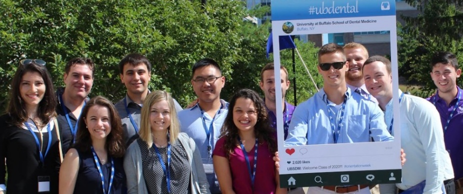 group of dental students standing outside in front of trees. 