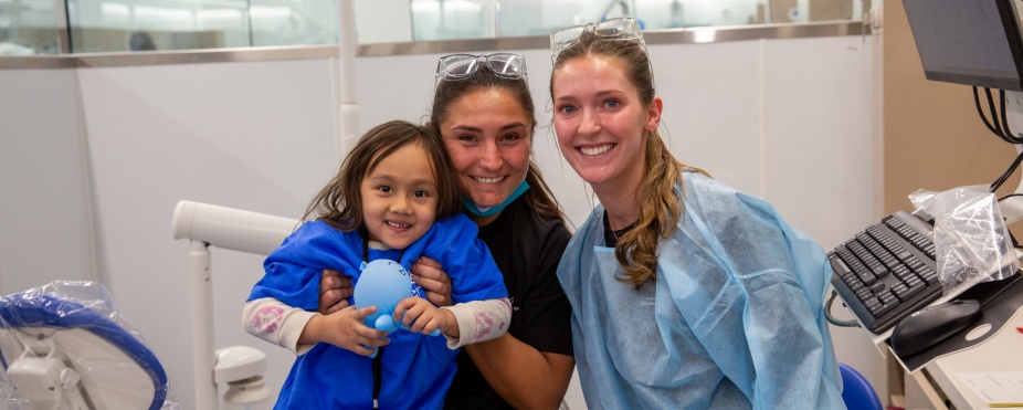students with a pediatric patient in the clinic. 