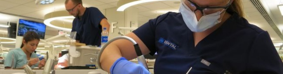 Dental student in scrubs working in our preclinical simulation lab. 