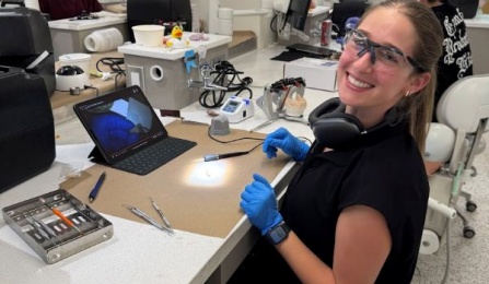 dental students sitting down and smiling in our pre clinical simulation center. 