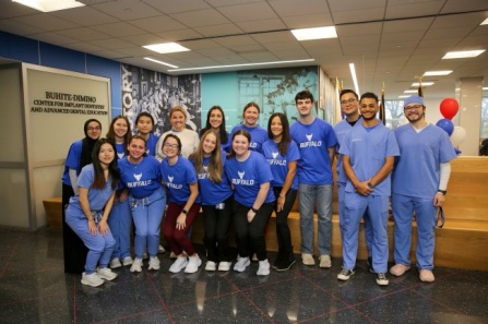 Group of dental students standing in the main Squire lobby. 