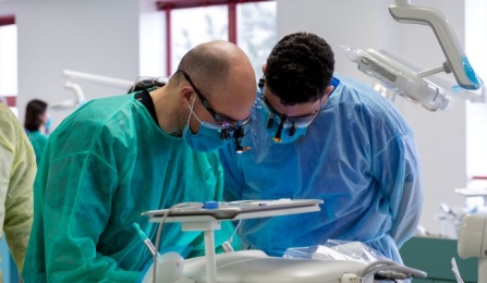 two dental studentsin the clinic wearing loupes. 
