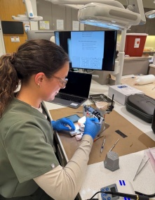 dental student working on benchtop in preclinic simulation lab. 