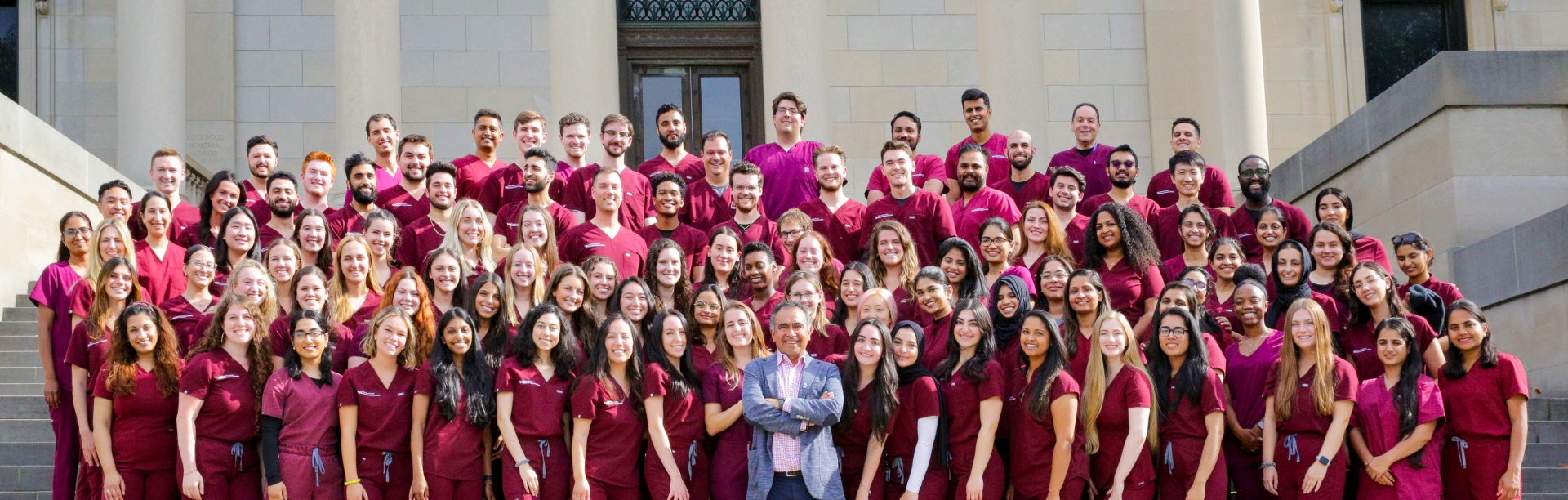 A class of dental students poses on the steps of the Health Sciences Library with Dr. Tapia. 