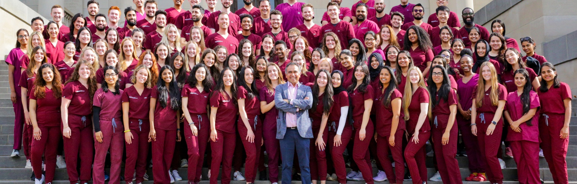 A class of dental students poses on the steps of the Health Sciences Library with Dr. Tapia. 