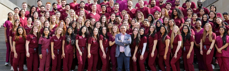 A class of dental students poses on the steps of the Health Sciences Library with Dr. Tapia. 