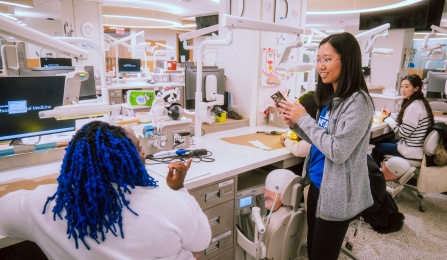 dental students in the preclinic simulation lab demonstrating equipment to prospecitve students. 