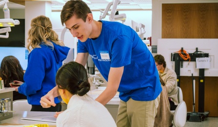 current dental student showing equipment to prospective student in the preclinic simulation lab. 