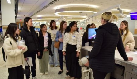 dental students giving a tour of the preclinic simulation lab to prospective students. 