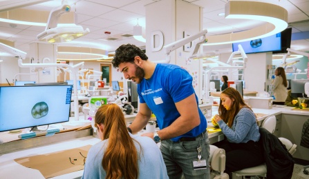 dental student working with prospective students in preclinic simulation lab. 