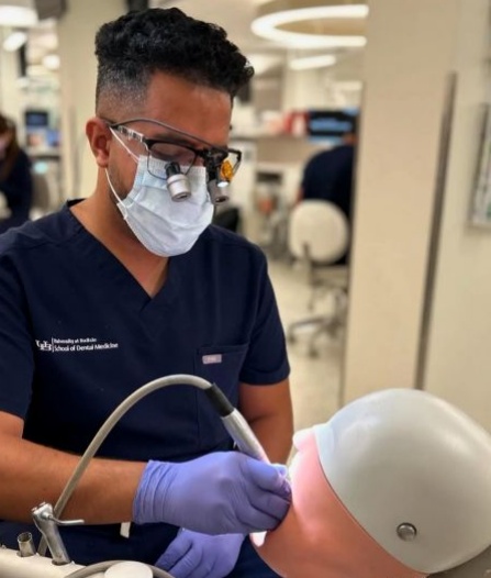 dental student working on mannequin in preclinic simulation lab. 