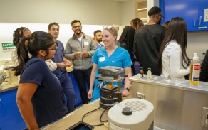 A current dental student showing prospective dental students around the preclinical simulation lab. 