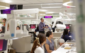 A faculty instructor in the preclinical simulation clinic teaching a class. 