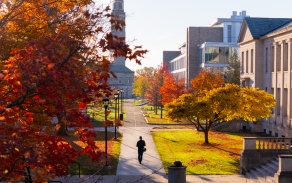 A student walking on South Campus in fall.