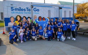 students pose in front of the mobile dental clinic for the Spike Oral Cancer event 2023. 
