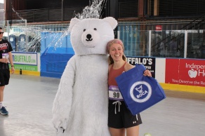 Student with mascot, Murray the Molar Bear, at the chasing healthy smiles 5k. 