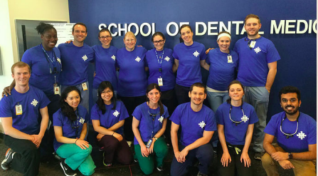 Members of AADMD club posing in front of School of Dental Medicine sign. 