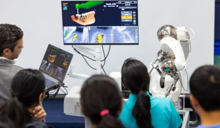 Dental students learning about robotic dentistry.