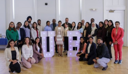 group of new international dentist program students with Dr. Arany standing in front of a large UB display. 