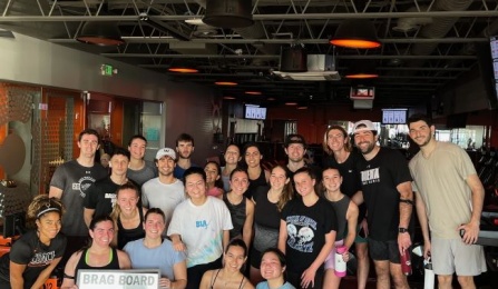 group of students standing and kneeling at the gym. 