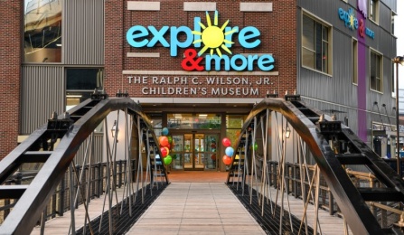 Image of outside Explore and More Museum with bridge leading to the front entrance and logo on the building. 