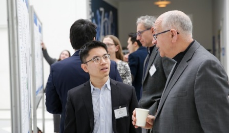 Faculty and Student staning in front of poster presentation having a discussion. 
