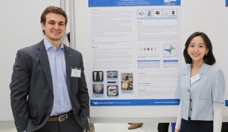 Two students standing in front of a research poster presentation. 