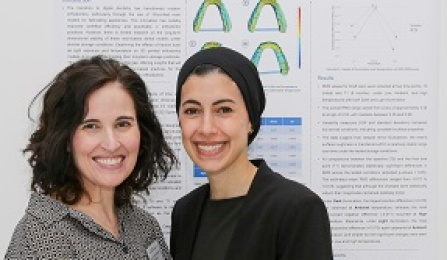 Two students standing in front of poster presentation. 