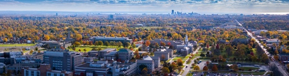 Aerial View of University at Buffalo South Campus with building, trees, and skyline. 