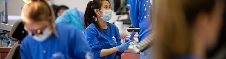 Dental student in clinic sitting at a dental chair working at our Give Kids a Smile Day event. 