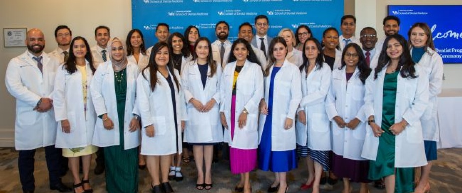 Group of International Students standing in white coats at the ceremony.