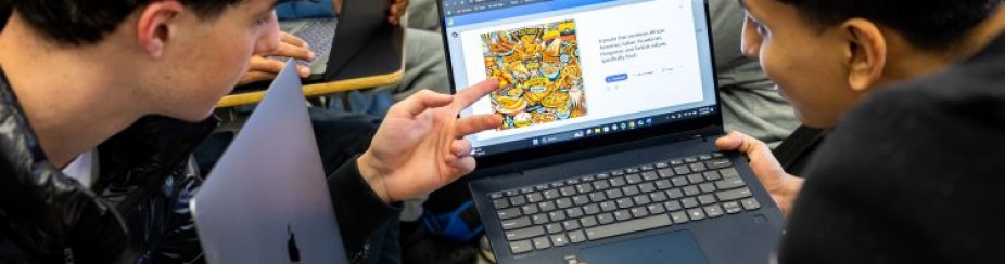 Students reviewed examples of AI generated work versus student work on notebook computer.