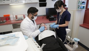 Two dentist examine a patient in a dental operatory. 