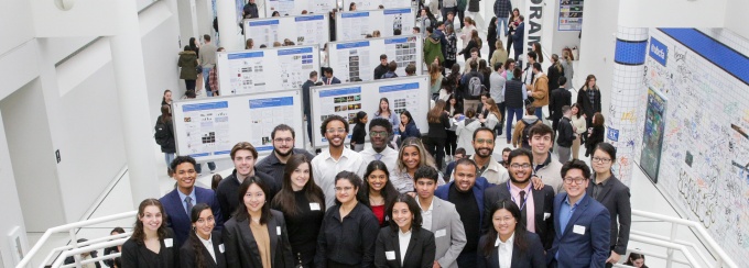 A photo of students who participated in the 2024 Student Research Day, posing in front of posters. 