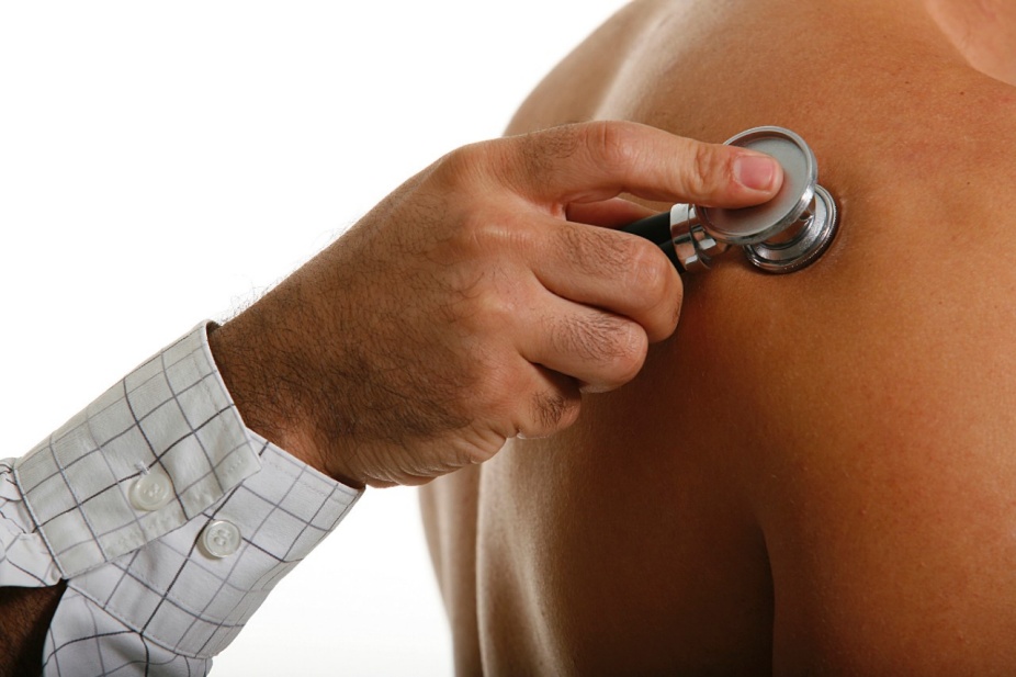 Close up view of a doctor using a stethoscope to examine a patient. 