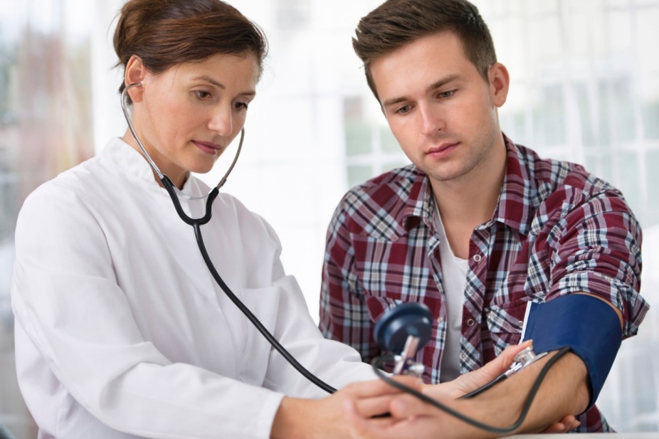 A doctor checks a patient's blood pressure.