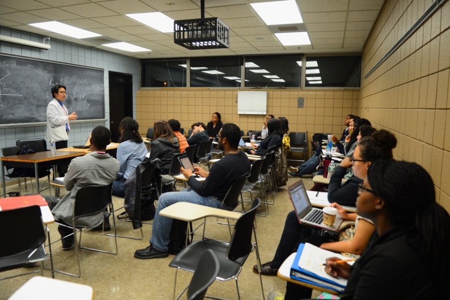 Nathanael Lee stands in front of a blackboard teaching students in UB's post-baccalaureate program aimed at boosting minorities who go to medical school. 