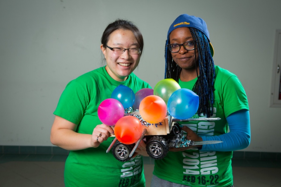 Students pose with robot. 