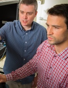 Mark Parker and Evan Meyers work at a computer in a lab. 