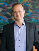 Dr. Lackner in front of microbiome graphic. 