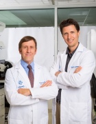 Bruce Troen, left, and Ken Seldeen, in white coats in lab. 