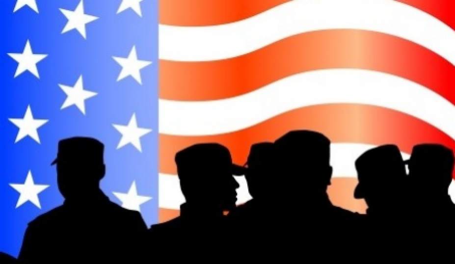 American flag in background and silhouettes of soldiers in foreground.