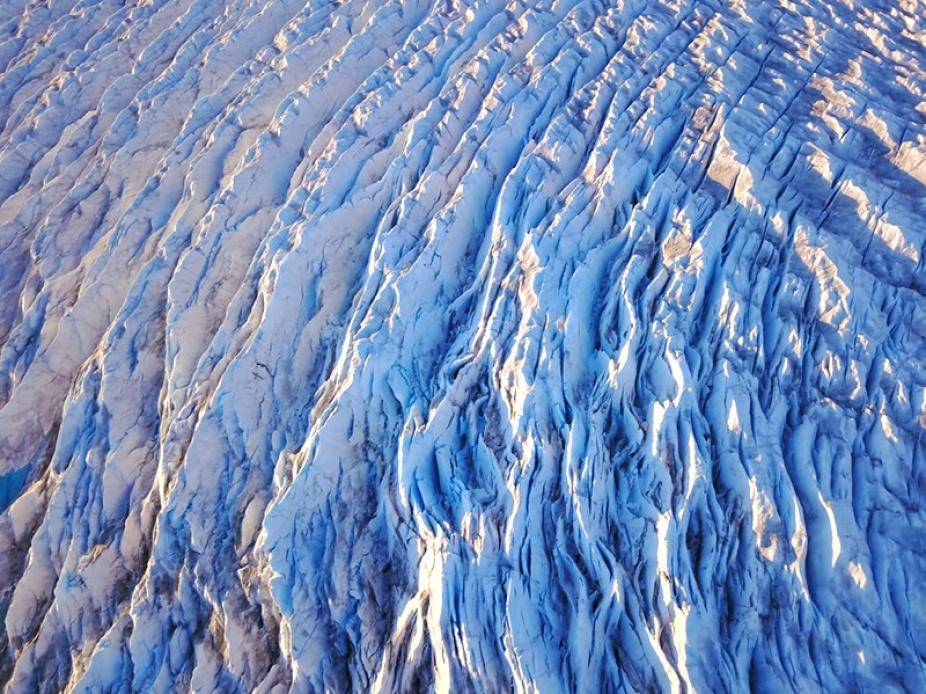 An aerial view of an ice sheet, showing large cracks called crevasses. 