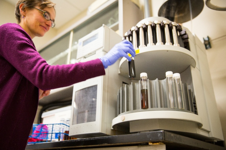 UB researcher Elizabeth Thomas places vials into a machine.