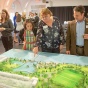 Photo of people viewing a large-scale model of conceptual designs for Ralph C. Wilson, Jr. Centennial Park. 