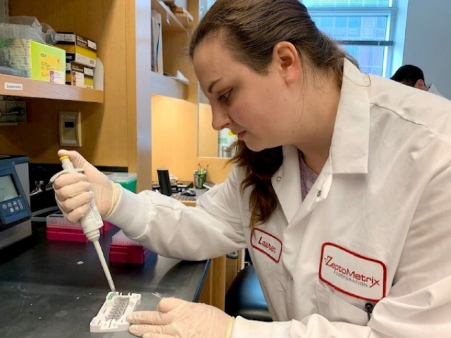 ZeptoMetrix molecular biologist Lauren Morrow loads reagents into a cartridge used in a digital droplet PCR platform with an automated droplet generator. Photo: Karuna Sharma. 