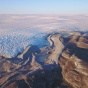 A rocky landscape meets a rippled surface of ice, as far as the eye can see. 