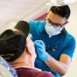 A dentist works on a veterans' teeth. 